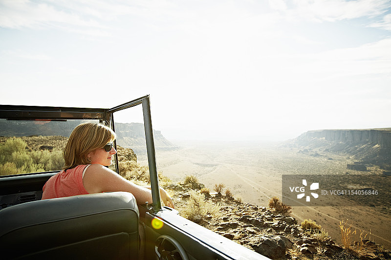女人坐在敞篷车里看着沙漠图片素材