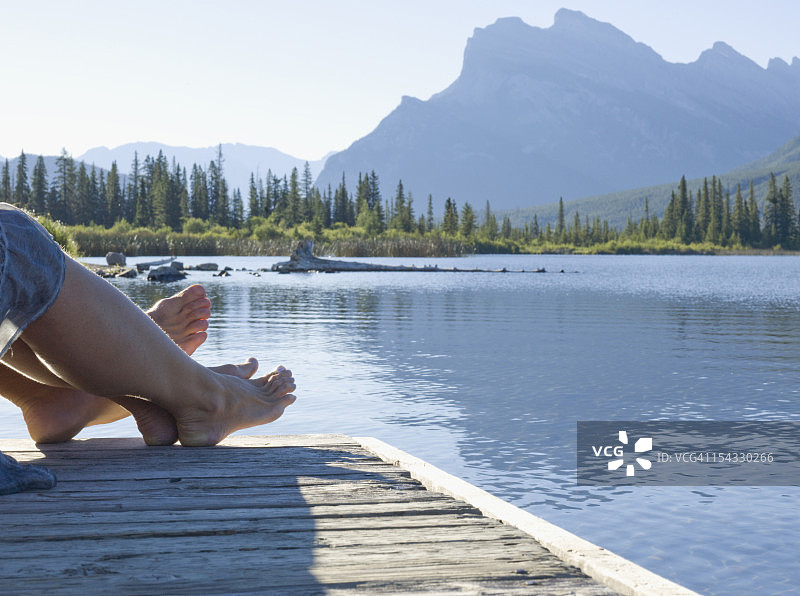 加拿大艾伯塔省班夫国家公园朱砂湖木制码头情侣足部山景图片素材