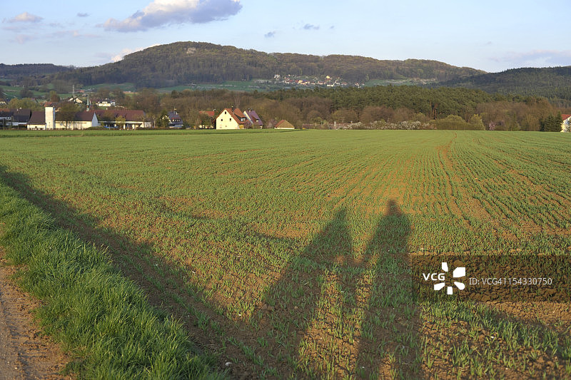 德国巴伐利亚：农场里两个人的影子图片素材