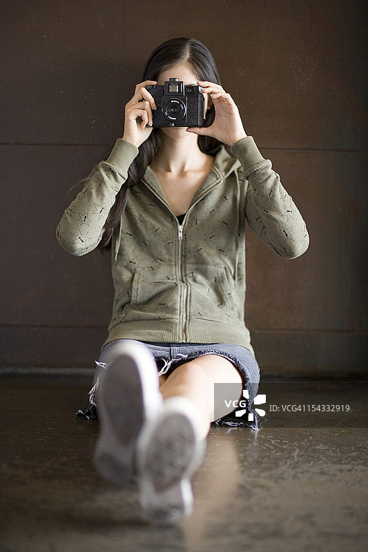 年轻女人用相机拍照图片素材