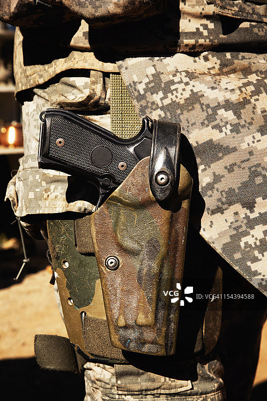士兵迷彩枪套中的贝雷塔手枪特写图片素材