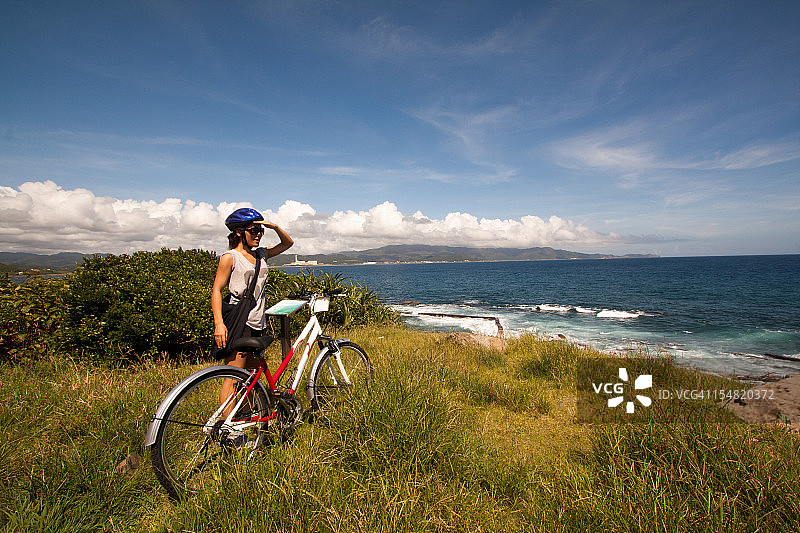 骑着自行车的女人看着大海图片素材