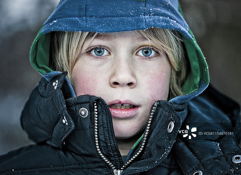 身穿冬季外套和雪的男孩图片素材
