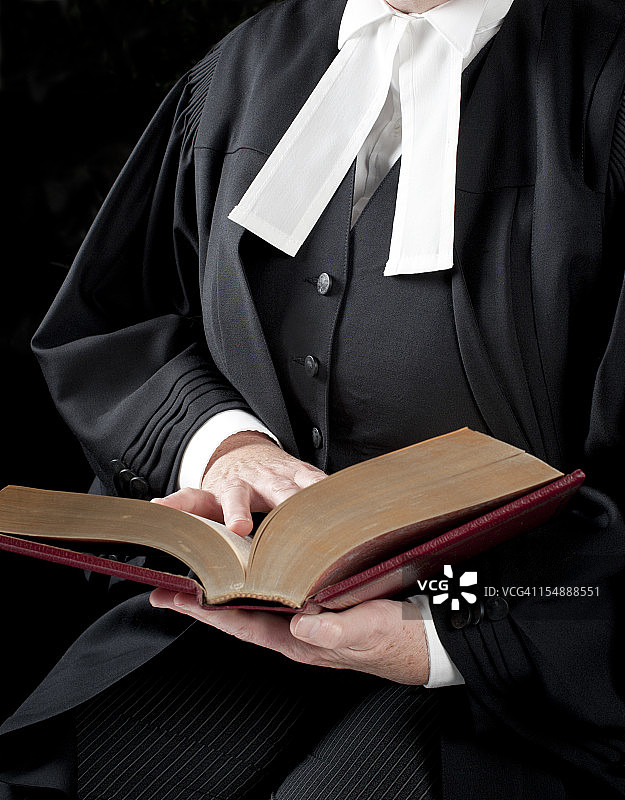 身穿正式法庭礼服的律师正在读书图片素材