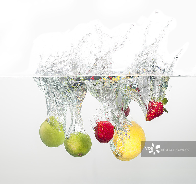 草莓、柠檬和酸橙鸡尾酒溅入水中图片素材