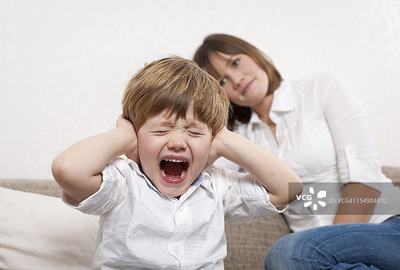 哭泣的男孩捂着耳朵图片素材