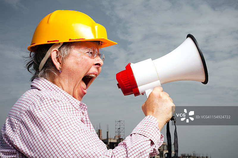 肖像年长的白人开朗的妇女工程师建筑师扩音器建筑工地图片素材