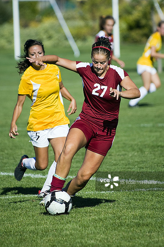 摆脱防守队员的红色女足球运动员图片素材
