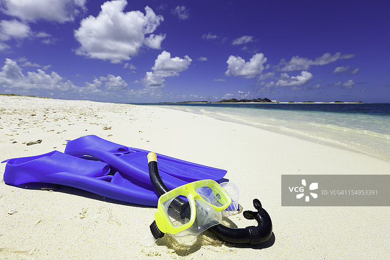 热带沙滩上的潜水面罩、呼吸管和脚蹼图片素材