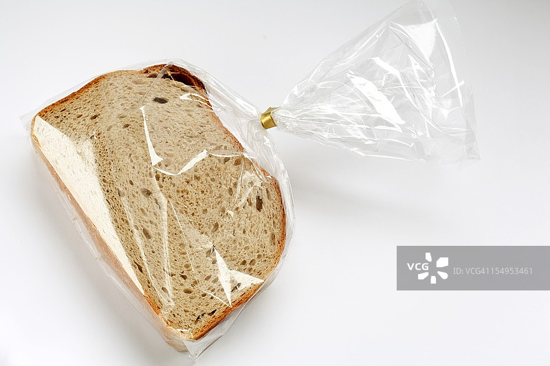 白色背景下透明塑料膜中的新鲜切片面包图片素材