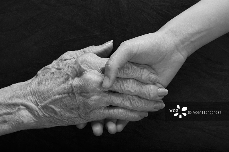 老人和年轻人的手伸出并握住图片素材