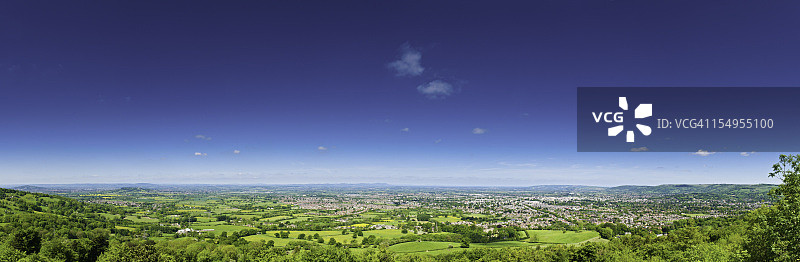 绿色田园风光与房屋全景上的蓝色夏日天空图片素材