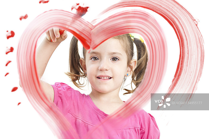 金发小女孩在窗户上用颜料画心形图片素材