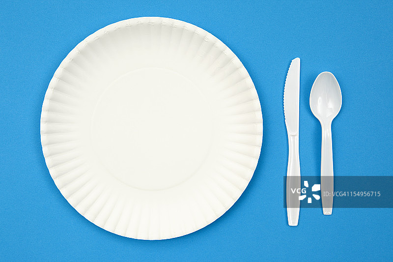 蓝色桌子上的纸盘和塑料餐具图片素材