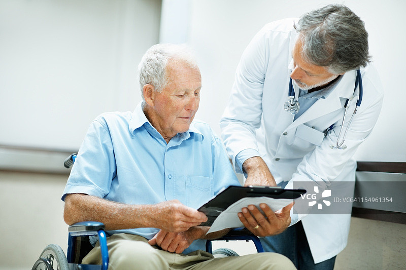 医生在医院向残疾男子讲解报告图片素材