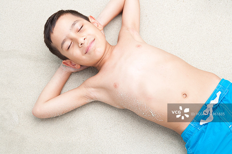 小男孩在海滩上放松图片素材