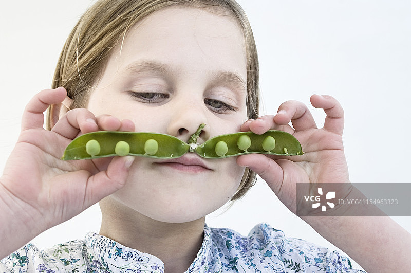 拿着豌豆荚当胡子的女孩肖像图片素材