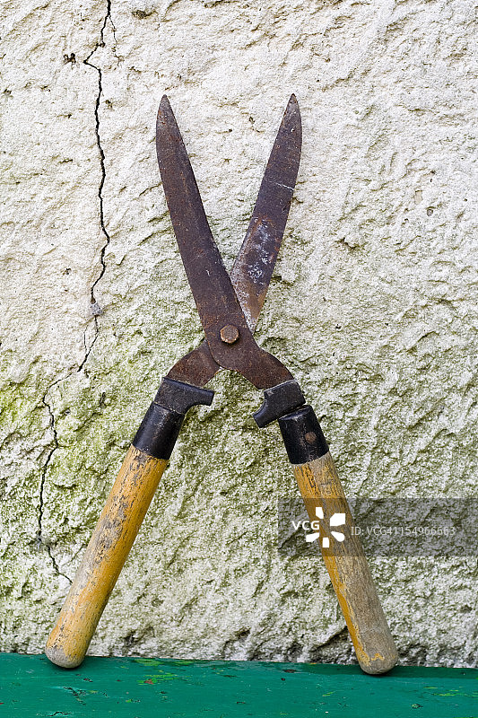 毁坏的乡村墙背景上的园艺剪刀图片素材