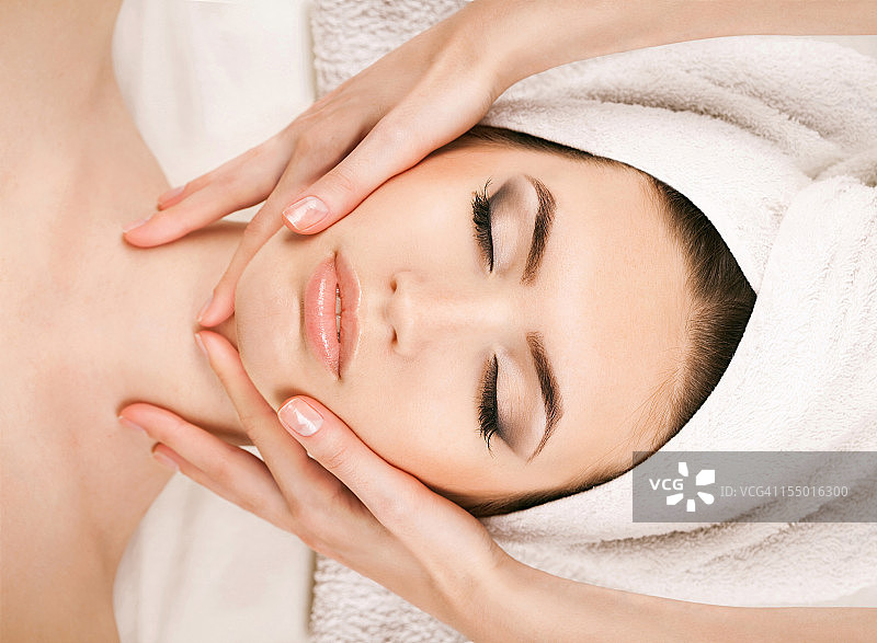 接受面部按摩的年轻女子肖像图片素材