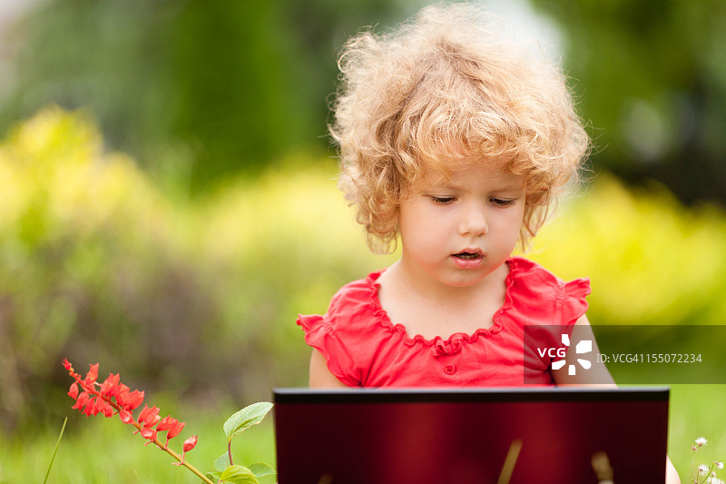 使用笔记本电脑的可爱小女孩图片素材