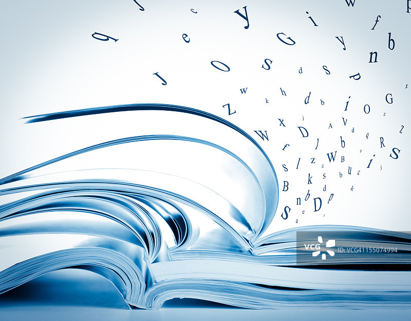 成堆打开的书籍杂志与飞舞的字母图片素材