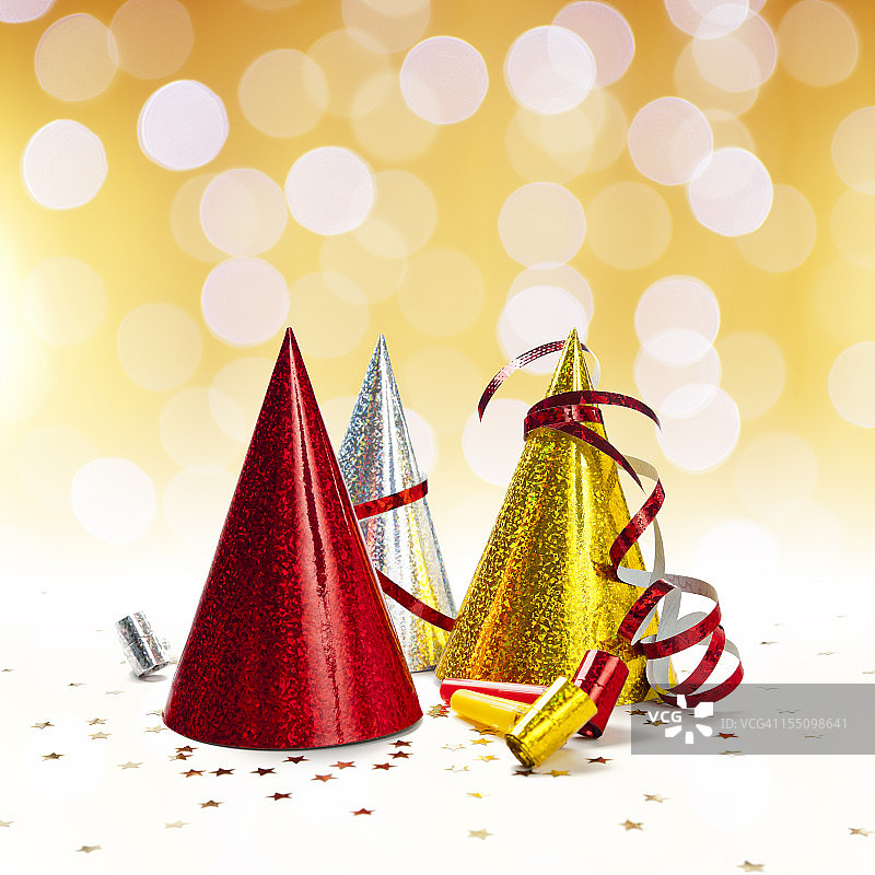 派对装饰：帽子、口哨、彩带、五彩纸屑金色灯光背景图片素材