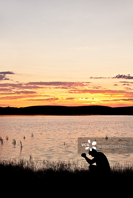 男人在湖边祈祷图片素材