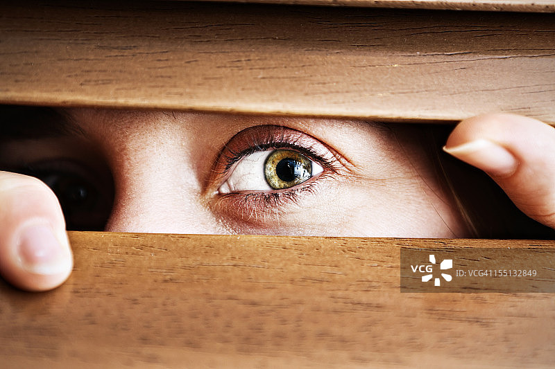 透过百叶窗窥视的焦虑女人图片素材