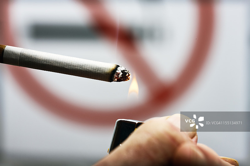 男子无视禁止吸烟标志点燃香烟图片素材