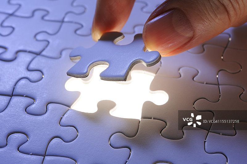 手持蓝色的最后一块拼图图片素材