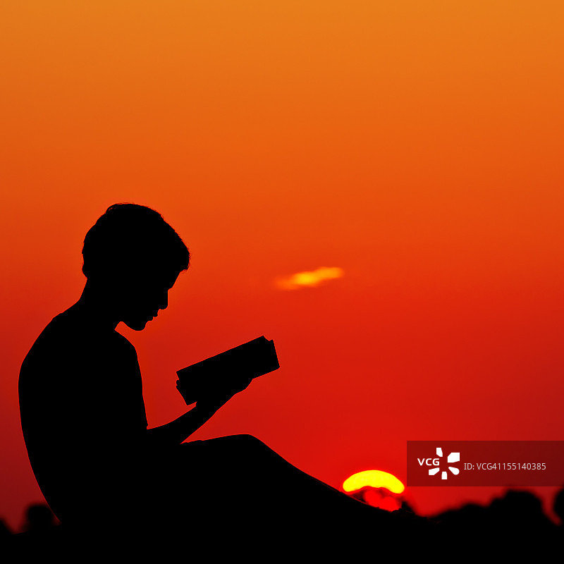 夏日落日下阅读的小男孩图片素材