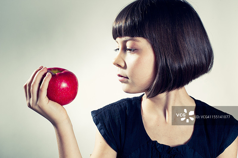准备吃红苹果的年轻女孩图片素材
