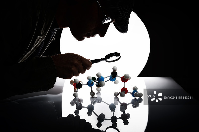 男人用放大镜观察分子结构图片素材