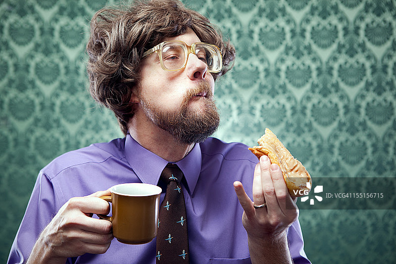 吃甜甜圈喝咖啡的办公室书呆子图片素材