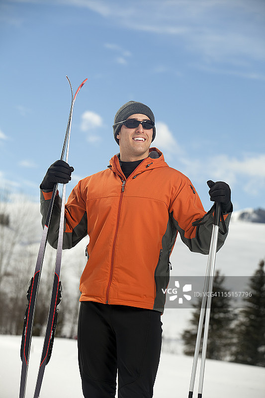 手拿滑雪装备的年轻男人图片素材
