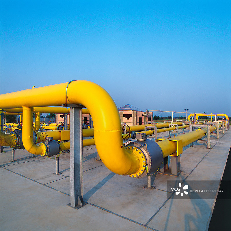 天然气配气站的黄色管道，蓝天背景图片素材