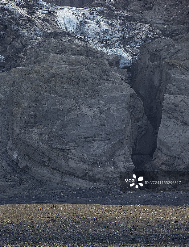 人们探索冰岛Gigjokull冰川的侧面图片素材