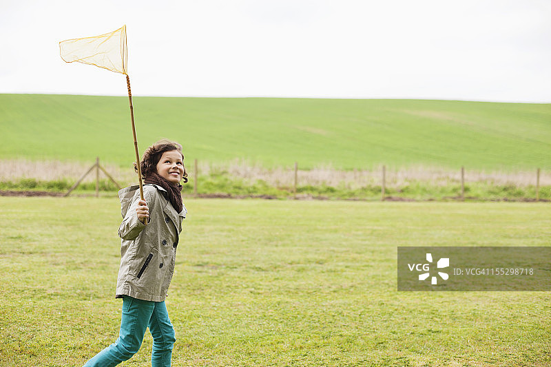 男孩在田野里拿着捕蝶网图片素材