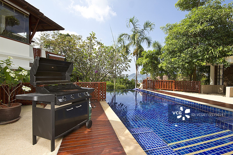 豪华住宅泳池旁的烧烤架图片素材