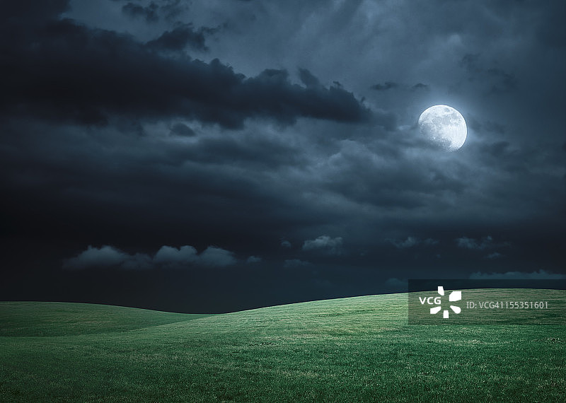 夜晚有满月和云朵的丘陵草地图片素材