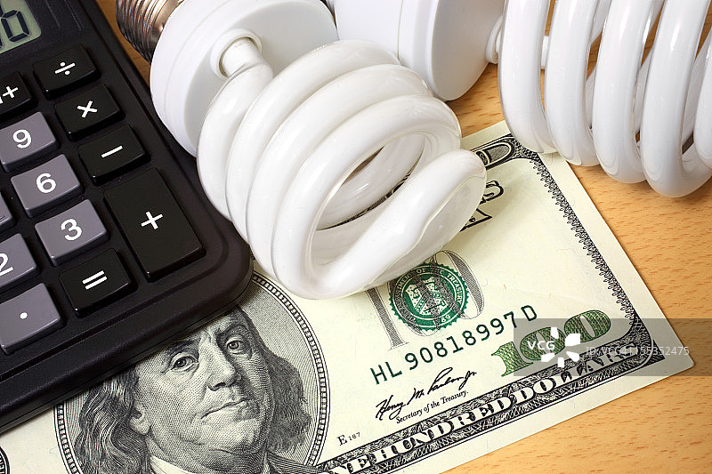 紧凑型荧光灯泡、计算器和百元美钞图片素材