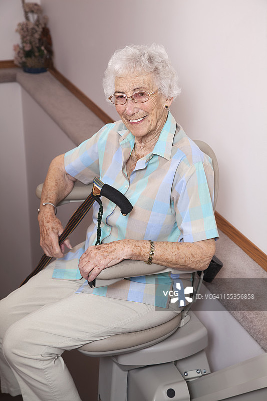 老年妇女使用楼梯升降椅：辅助生活图片素材