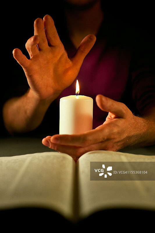 手和圣经旁的蜡烛图片素材
