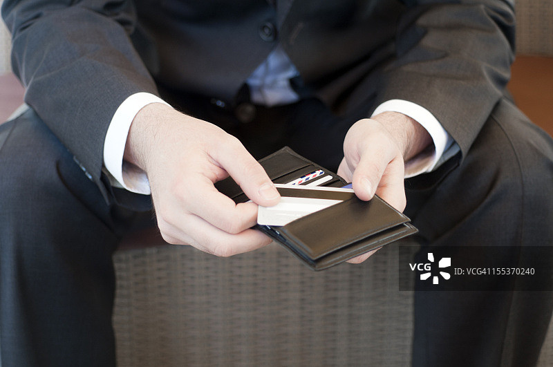 商人从钱包里拿出信用卡图片素材