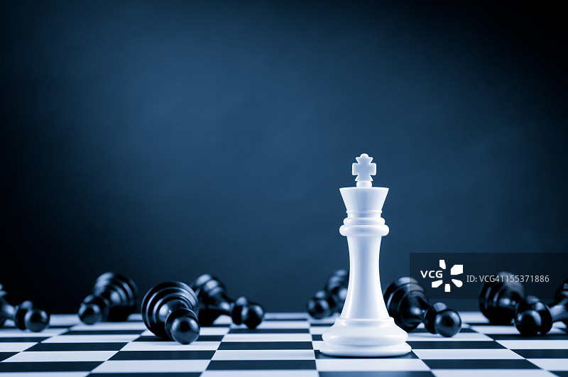 棋盘上黑色卒子中的白色国际象棋国王图片素材