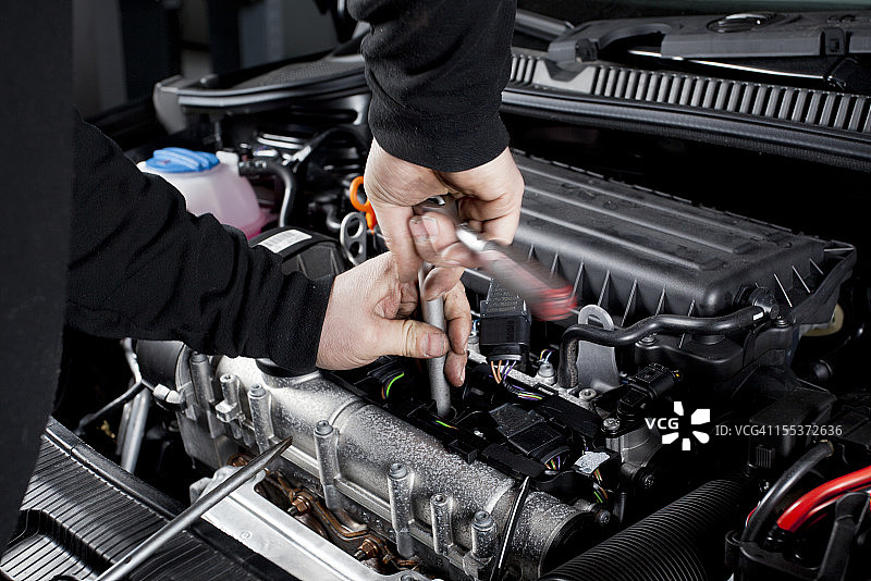 技工拧开现代汽车的点火塞图片素材