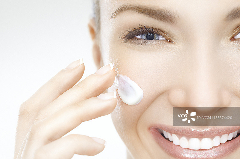 美丽女人涂抹面霜特写图片素材