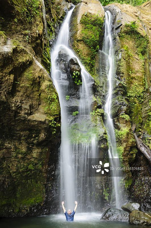 在瀑布下乘凉的男人图片素材
