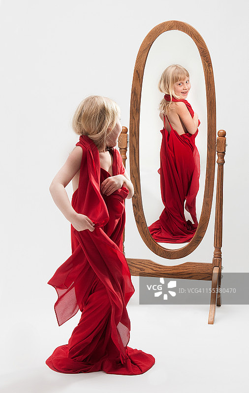 小女孩穿着礼服/玩装扮游戏——在镜子里的倒影图片素材