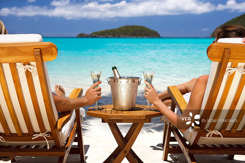 在加勒比海滩喝香槟的蜜月夫妇图片素材